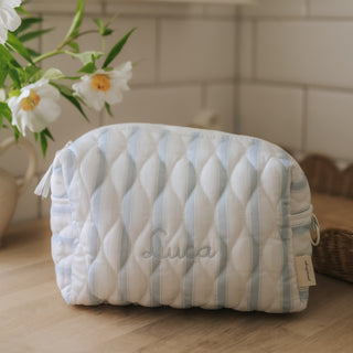 Quilted pouch with striped pattern on a wooden surface, featuring the name 'Luca'