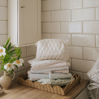 Quilted toiletry pouch on stack of towels