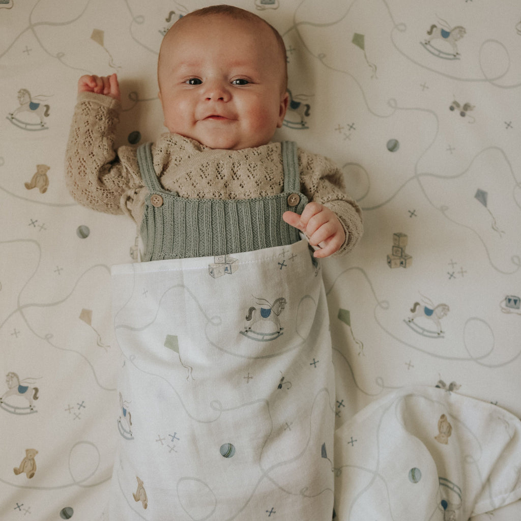 Baby lying on a crib with a patterned sheet