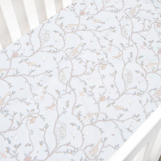 Animal Parade in blue patterned crib sheet on a white crib