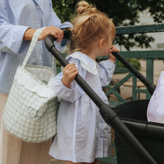 Mom and child on a walk with a stroller, mom holding a Green gingham storage basket 
