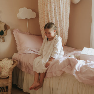 Scalloped Starlight Twin Duvet Set in Rose with little girl on bed smiling