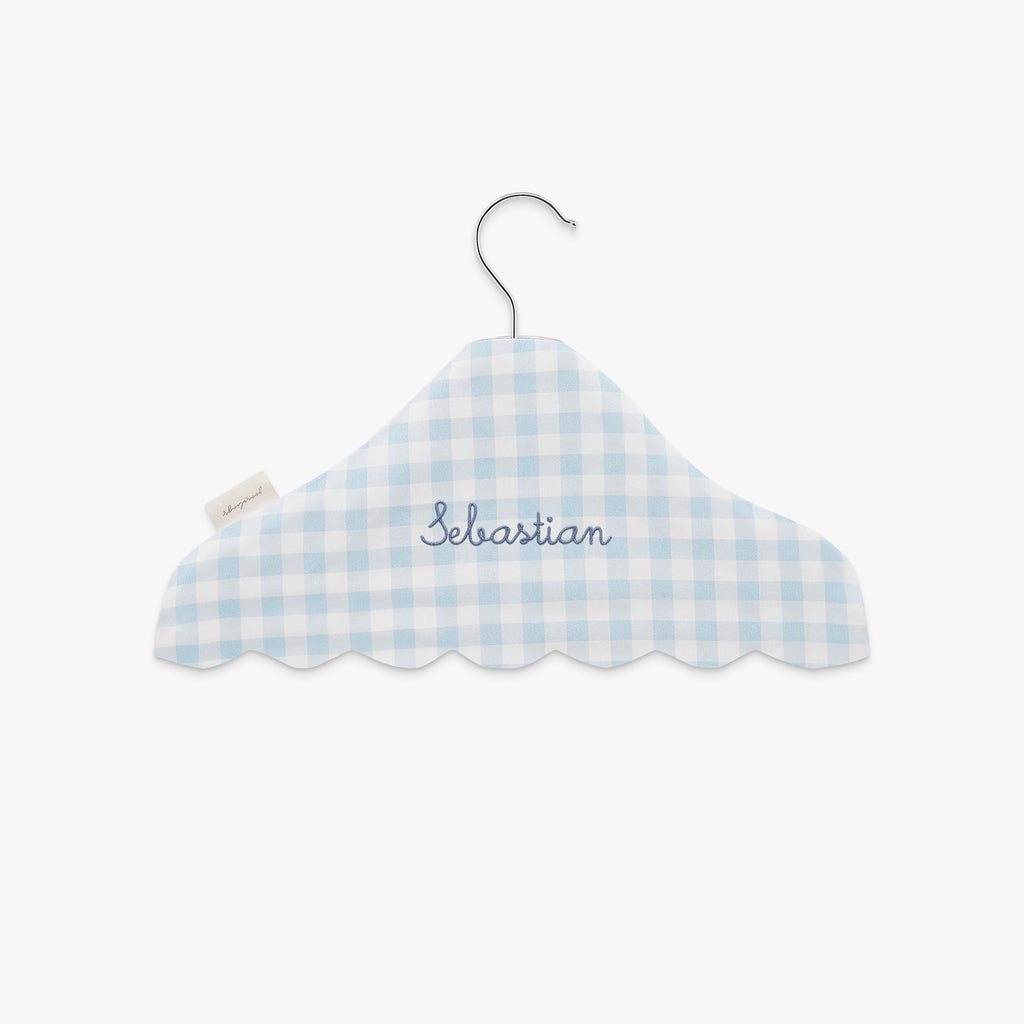 Blue and white checkered cloud-shaped hanger with 'Sebastian' embroidery on a white background