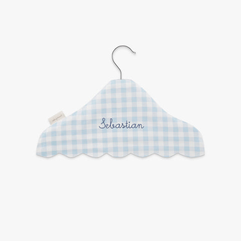Blue and white checkered cloud-shaped hanger with 'Sebastian' embroidery on a white background