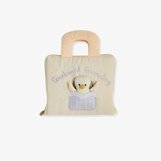 Children's book with plush goose inside on a beige background