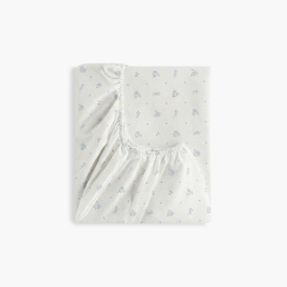 Fitted crib sheet with subtle pattern on a white background