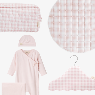 Collection of pink baby clothing and accessories with gingham patterns on a white background