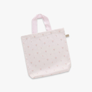 Pink tote bag with subtle floral pattern on a light gray background