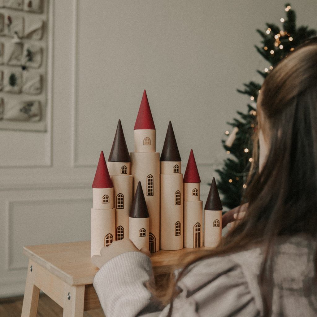 Fairytale Kingdom Tower with wooden cones and little girl adjusting the tower