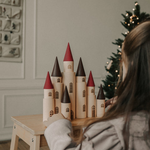 Fairytale Kingdom Tower with wooden cones and little girl adjusting the tower