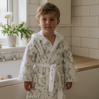 Child wearing a floral robe in a bathroom