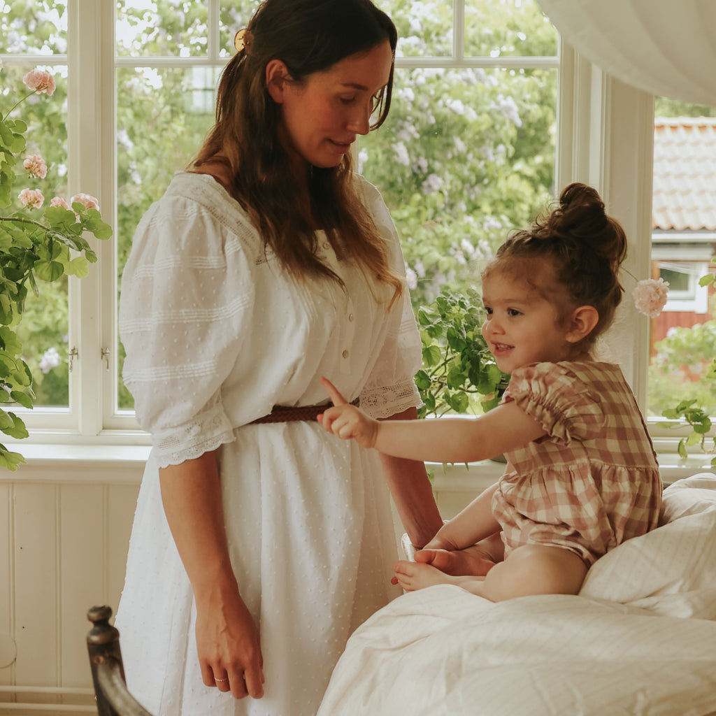 Petal Scallop Baby Duvet with child sitting on top with mother by side