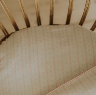 Petal Scallops Crib Sheet in Pink displayed in crib