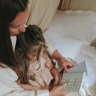 Woman and child looking at a photo album together on a bed