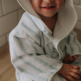 Child wearing a striped robe indoors