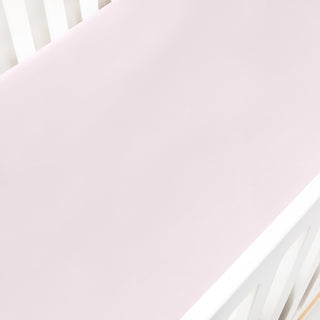 Solid Soft Pink crib sheet on a white crib