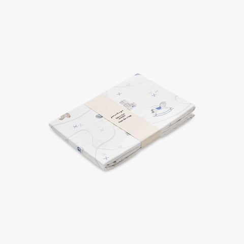 Folded baby swaddle with rocking horse and toy designs on a white background