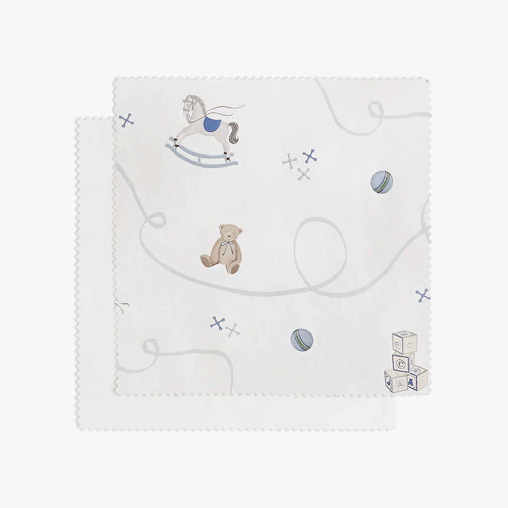 White fabric swatch with teddy bear and toys on a white background