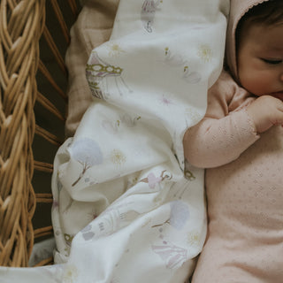 Adventures in Wonderland Swaddle in rose with baby laying on top