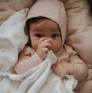 Adventures in Wonderland Swaddle in Rose wrapped around baby 