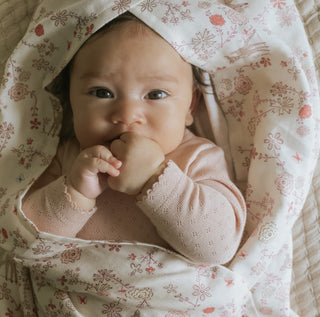 Into The Woodlands Swaddle in Ivory wrapped around baby