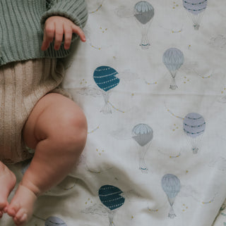 Touch The Sky Swaddle in Blue with baby laying on top
