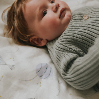 Touch The Sky Swaddle in Blue with baby laying on top