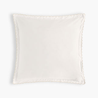 White decorative pillow with scalloped edge on a white background