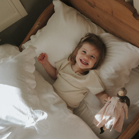 Scalloped Starlight Twin Set in White with child smiling laying in bed
