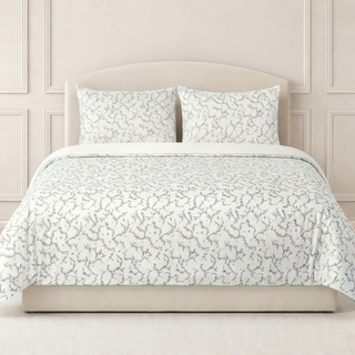 Secret garden l patterned bedding set on a bed with a neutral headboard.