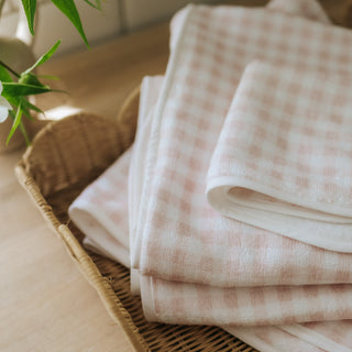 Baby hooded towel in Pink Gingham in a stack. 