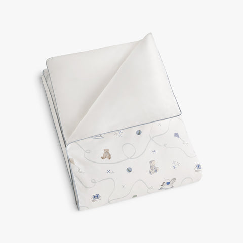 folded rocking horse and teddy bear patterned blanket on a white background