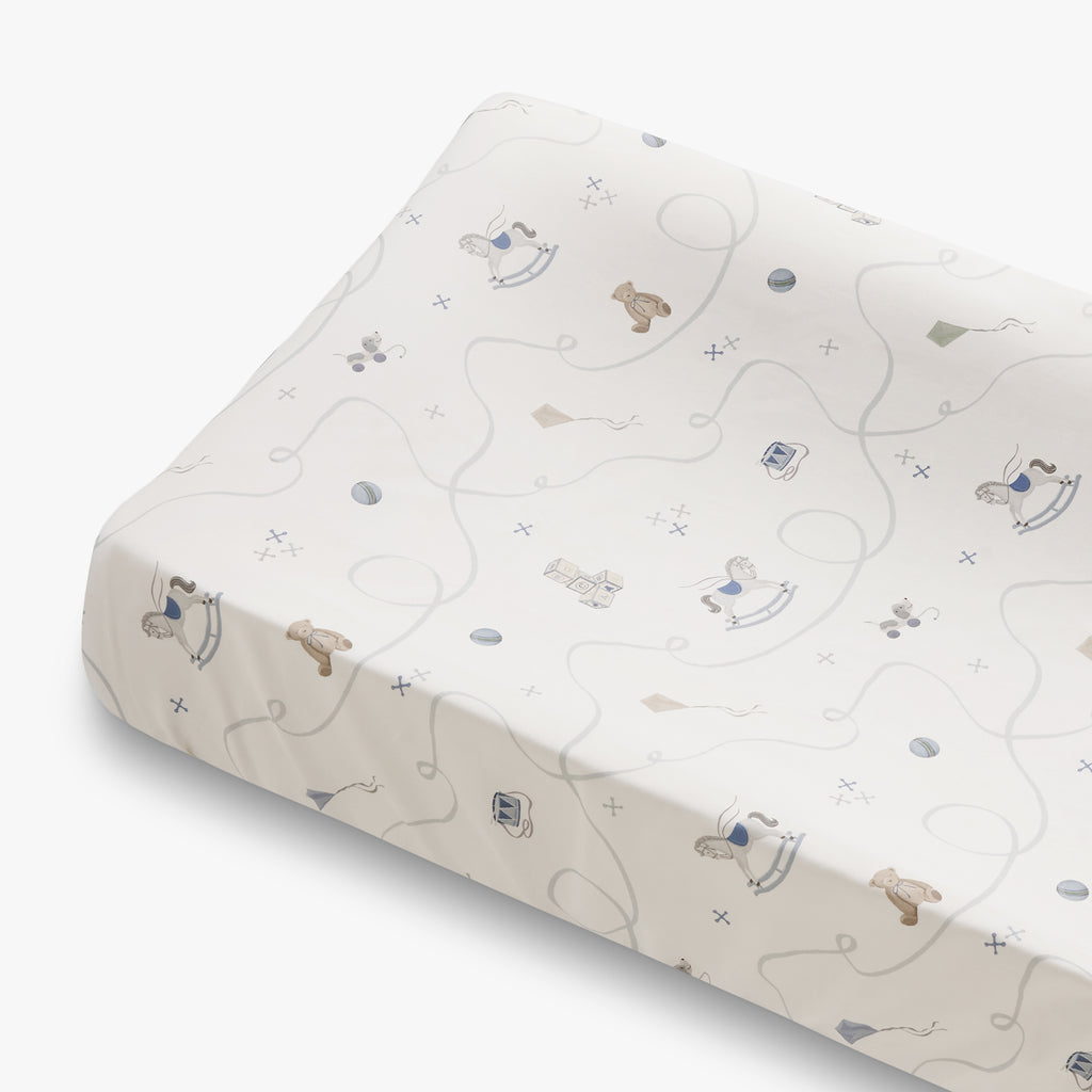 Baby changing pad with toy animal design on a white background