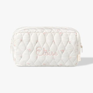 Toiletry pouch with Ditsy Floral print and Eloise monogram across the center in pink.