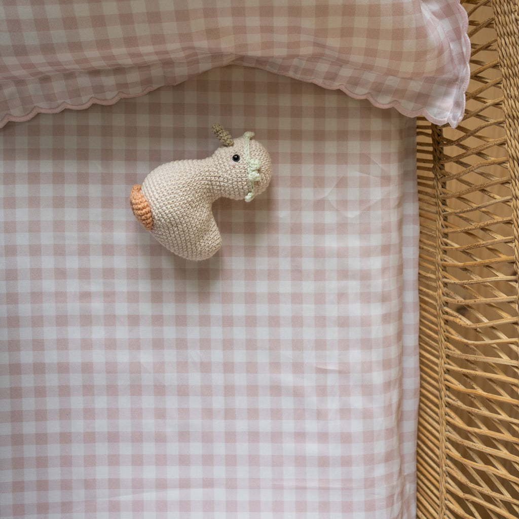 Pink Gingham Crib Sheet in Straw Crib with gooselings on top