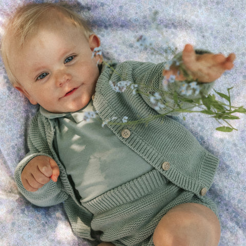 Baby laying on the wildflower print reaching for a flower