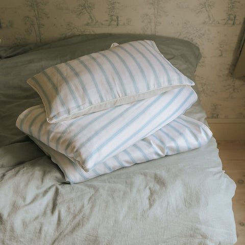 Toddler Pillow in coastal Stripes Blue laying on a bed
