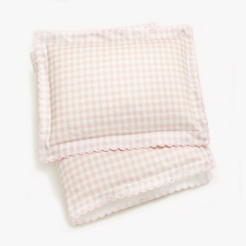 Toddler duvet folded with toddler pillow on top in the Picnic Gingham in the color pink