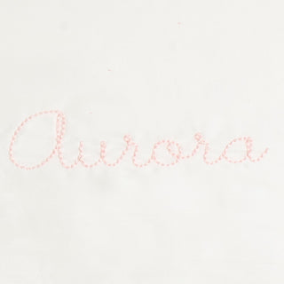 Monogram in pink color thread the name "Aurora"