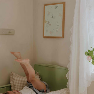Art work on wall with a child in bed