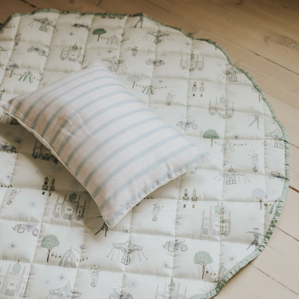 Adventures in Wonderland playmat in Aqua on the floor with a pillow on top