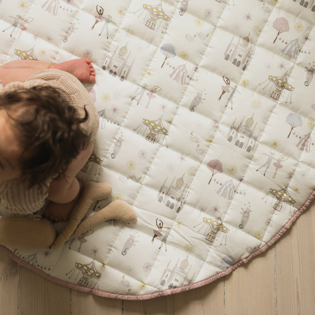 Adventures in wonderland playmat in rose. Child playing on playmat