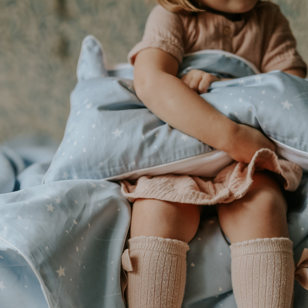 Toddler playing with the Toddler Pillow in the "Once Upon A Time" print in blue