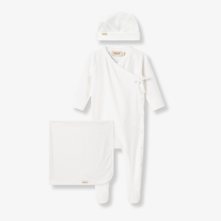 White baby outfit with hat, blanket, and booties on a white background