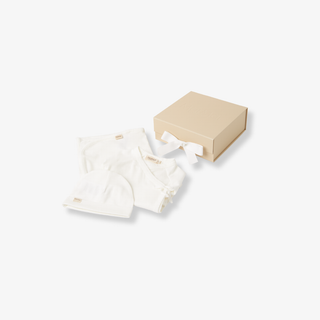 White baby outfit with a beige box on a white background
