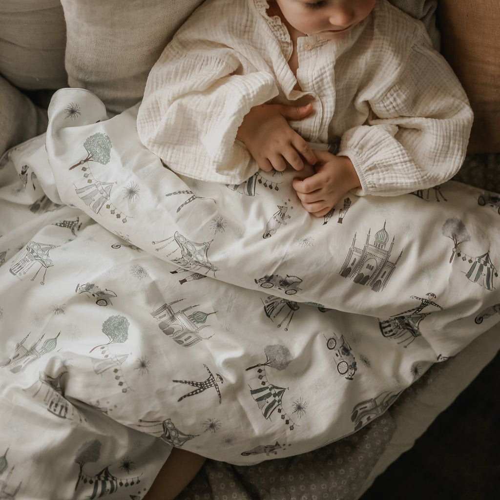 Upclose print details of the Adventure in Wonderland Twin Duvet in Aqua with a Child Resting Underneath