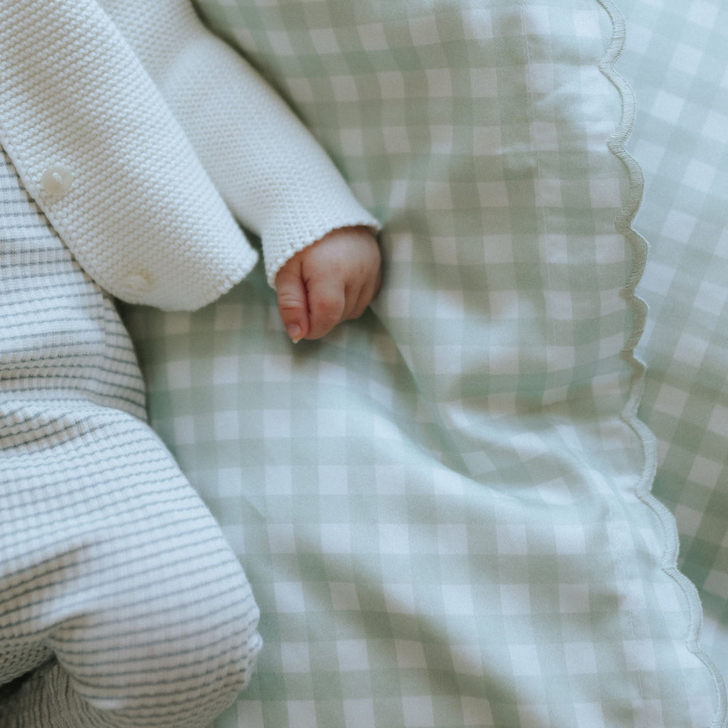 Picnic Gingham Green Baby Duvet with sleeping baby laying on top