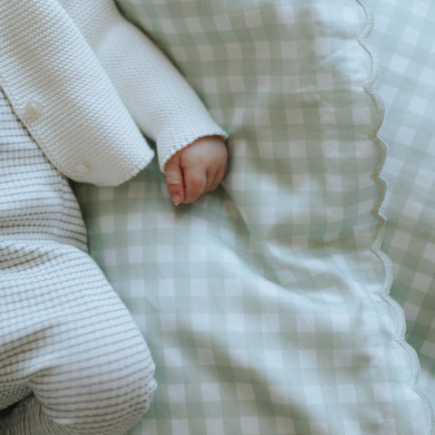 Picnic Gingham Green Baby Duvet with sleeping baby laying on top