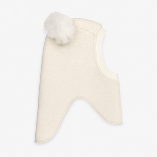 A cream-colored child's balaclava with two fluffy pom-poms on the top, shown against a plain light gray background.
