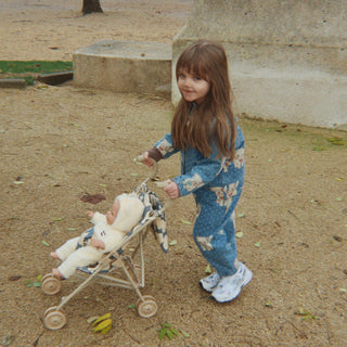Child playing with a doll in a stroller outdoors